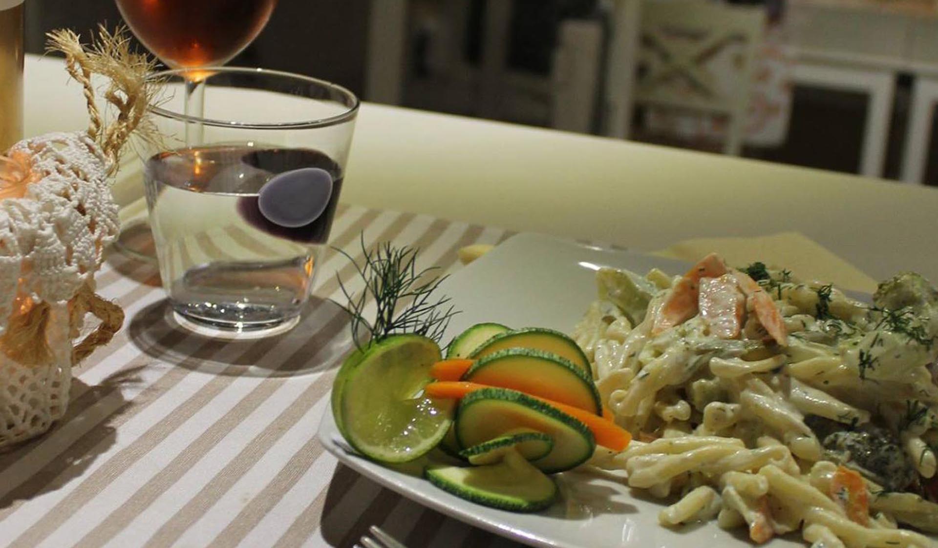 Τραπέζι με πιάτο ζυμαρικών και κρασί